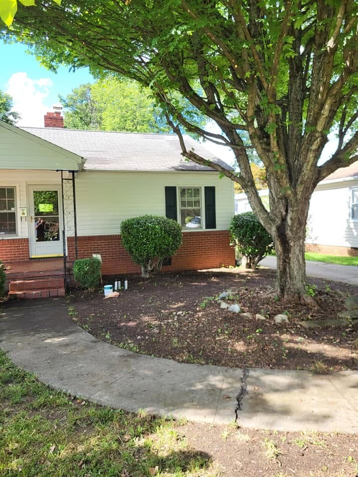 Brick ranch home with shrubs trimmed and beds cleaned up